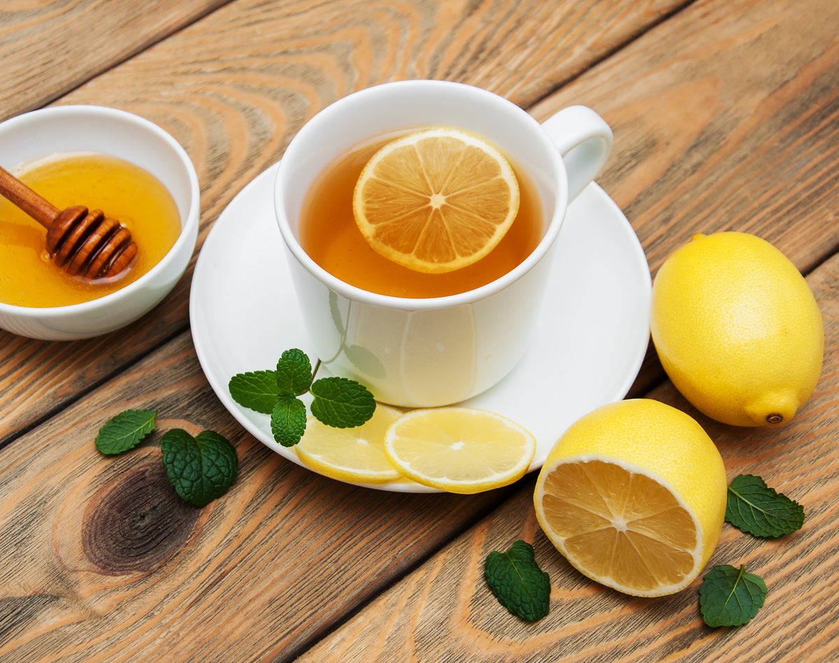 Cup of tea with lemon and ginger on wooden surface