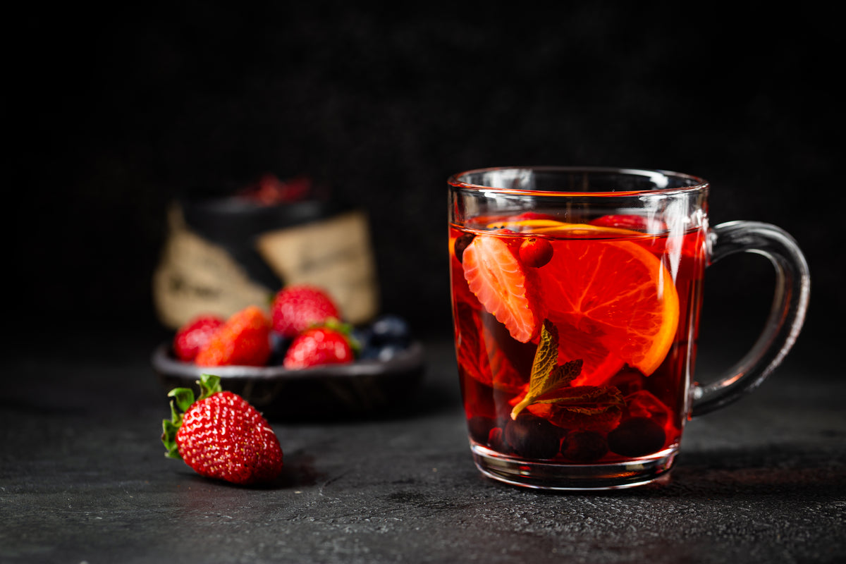 Fruit red tea with berries in glass cup